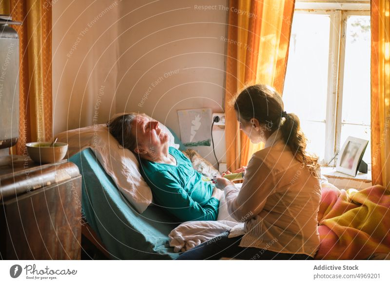 Sozialarbeiter, der eine behinderte reife Frau füttert Krankenpfleger geduldig Futter älter gelähmt Püree Pflege Frauen heimwärts Art Spritze Tube Behinderung