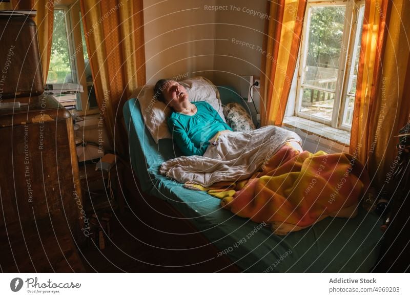 Gelähmte ältere Dame, die zu Hause auf dem Bett liegt Frau gelähmt heimwärts medizinisch Raum Behinderung Pflege geduldig Senior reif Rentnerin abstützen