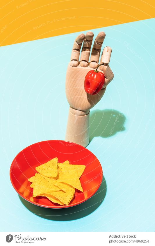 Künstlicher Arm mit Habanero-Pfeffer in der Nähe von Tortilla-Chips Paprika Hand Tradition Speise heiß habanero Konzept bo