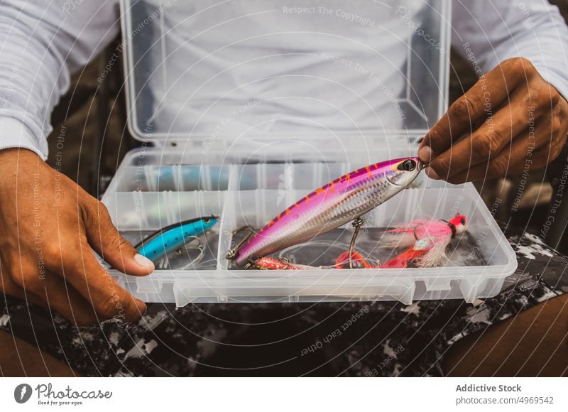 Unbekannter Angler mit Angelausrüstung Fischer Fischen anpacken Stecker ködern Container sortiert Landschaft Gerät Vorrat verschiedene Kunststoff männlich Hobby