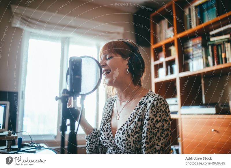 Sängerin singt zu Hause ein Lied ins Mikrofon singen Gesang Aufzeichnen Musik Headset professionell Produzent benutzend Apparatur Frau leer Fokus Klammer
