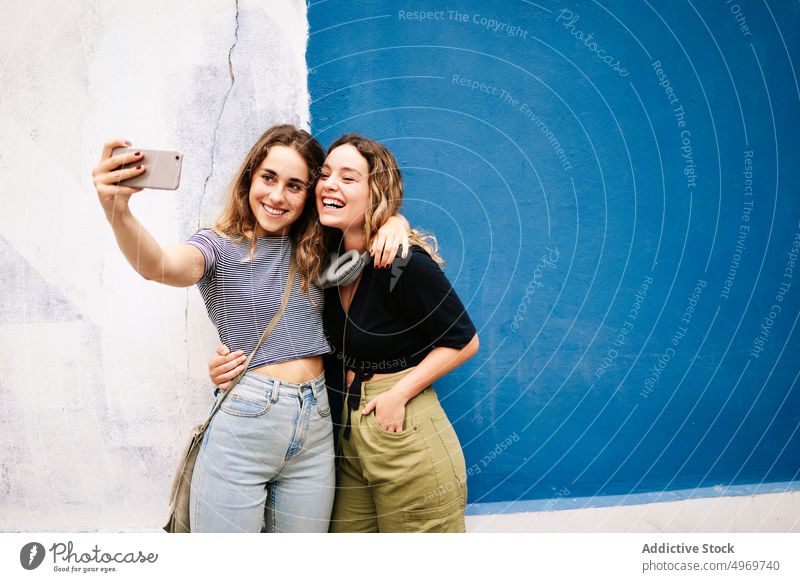 Frauen machen Selfie mit Smartphone Selfie nehmen Bild umarmend Fotoapparat benutzend Straße Sitzung Freundschaft Fotografie laufen Bonden Gerät Apparatur