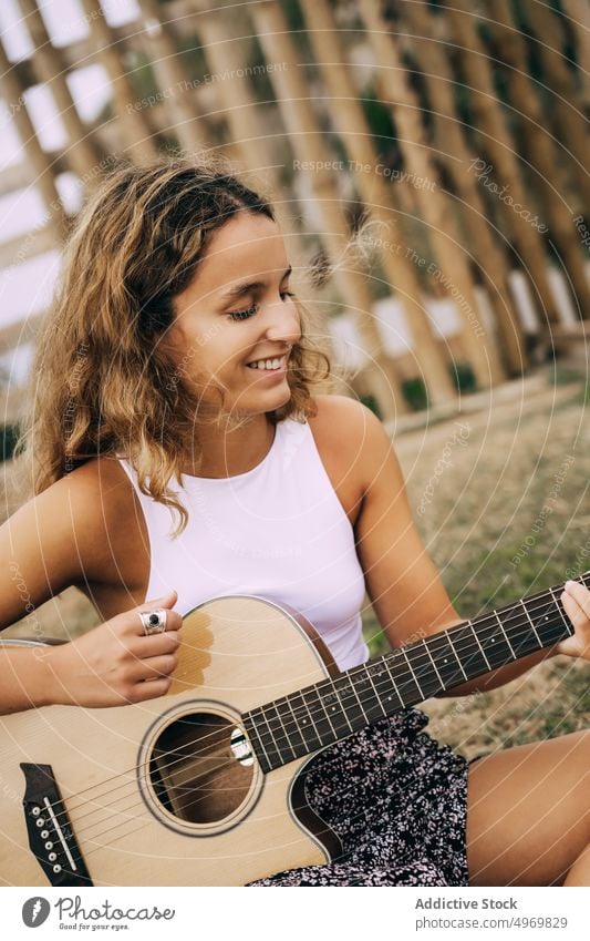 Frau spielt Gitarre in einem Feld mit trockener Vegetation Musik Spielen romantisch jung spielen Instrument heiter Musical Spaß Urlaub Mode Feiertag lässig