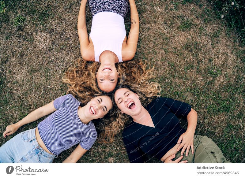 Entspannte Freundin im Gras liegend mit Köpfen im Kreis und lachen Frauen Park Freunde Lügen Rasen Glück Freundschaft Lächeln Zusammensein heiter attraktiv Spaß