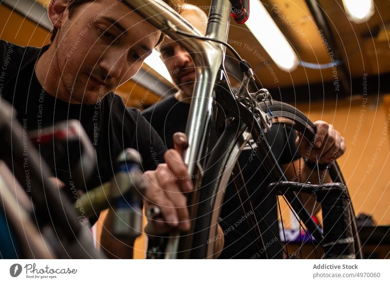 Mechaniker, der ein Fahrradrad repariert Werkstatt Werkzeug Rad Reparatur Anpassung Arbeit Dienst Job professionell prüfen fixieren Fahrzeug Verkehr Beruf