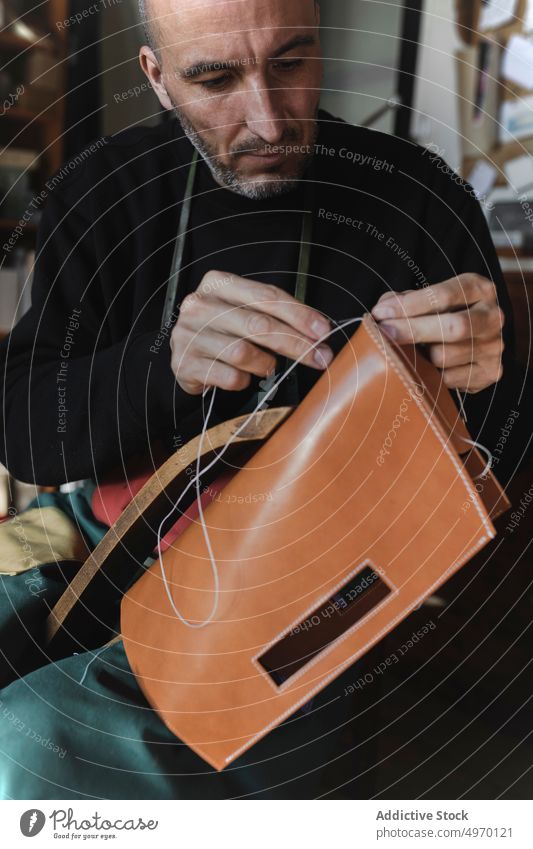 Mann näht Textil im Atelier Schneider Nähen Nadel Werkstatt Leder dickey Arbeitsplatz Mode Bekleidung Damenschneiderin Design Handwerk Gewebe Industrie Basteln
