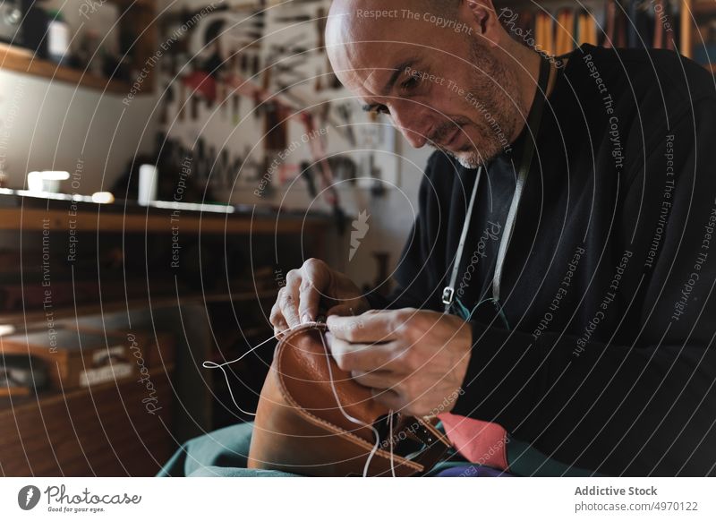 Mann näht Textil im Atelier Schneider Nähen Nadel Werkstatt Leder dickey Arbeitsplatz Mode Bekleidung Damenschneiderin Design Handwerk Gewebe Industrie Basteln