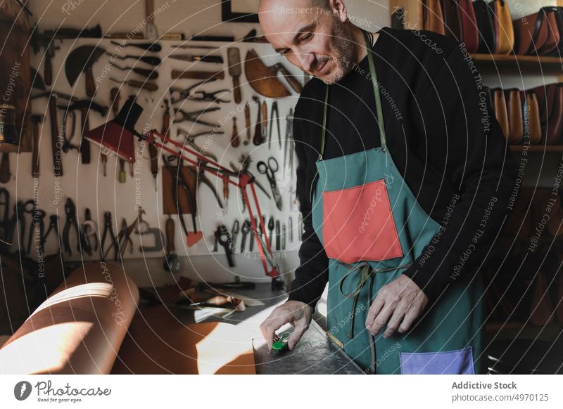 Mann schneidet Textil im Atelier Schneider Werkstatt Leder Schneiden Nähmaschine dickey Presse Arbeitsplatz Mode Bekleidung Damenschneiderin Design Handwerk