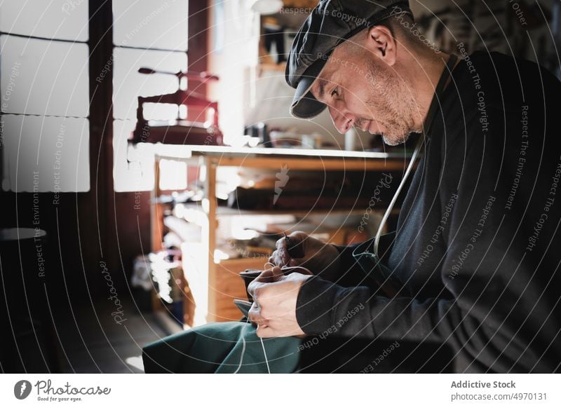 Mann näht Textil im Atelier Schneider Nähen Nadel Werkstatt Leder dickey Arbeitsplatz Mode Bekleidung Damenschneiderin Design Hut Handwerk Gewebe Industrie