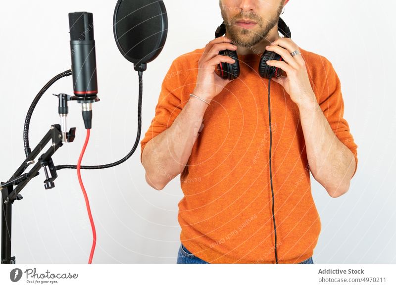Anonymer talentierter Mann singt im Studio Aufnahme Atelier Gesang singen Mikrofon Industrie Audio Musik Stimme Kopfhörer Vorrichtung Arbeitsplatz männlich