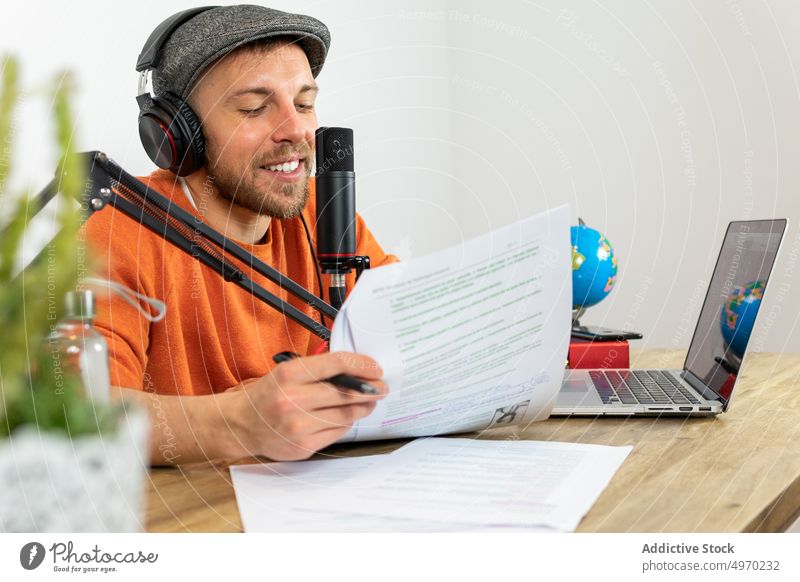 Beschäftigter Mann, der am Tisch mit Mikrofon einen Podcast über das Reisen aufnimmt Radio Ausstrahlung reisen Atelier Audio Aufzeichnen Arbeitsplatz