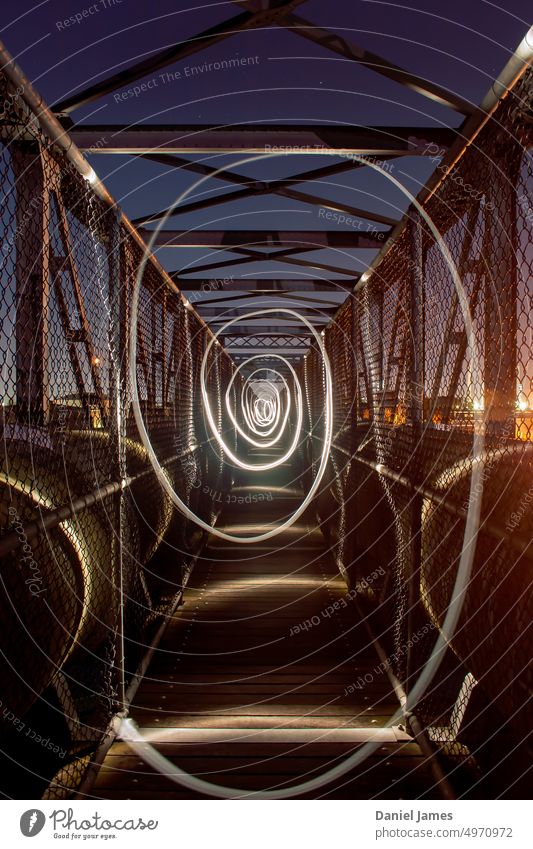 Wirbelndes Fackellicht auf einem Industriesteg. industriell Brücke Steg Nacht Taschenlampenlicht abstrakt Verwirbelung herumwirbeln Spirale verdrehen kreisrund
