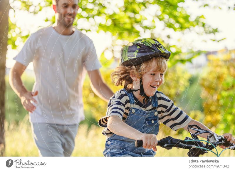 Vater bringt seinem Sohn das Fahrradfahren bei Tag Gesunder Lebensstil aktiver Lebensstil im Freien Spaß Freude Radfahren Aktivität Radfahrer genießend