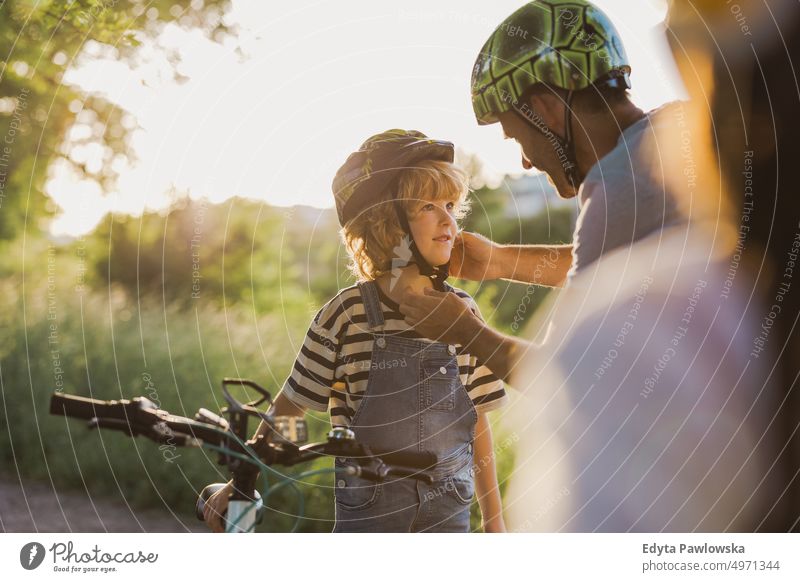 Aufnahme eines Vaters, der den Helm seines Sohnes zurechtrückt Tag Gesunder Lebensstil aktiver Lebensstil im Freien Spaß Freude Fahrrad Fahrradfahren Radfahren
