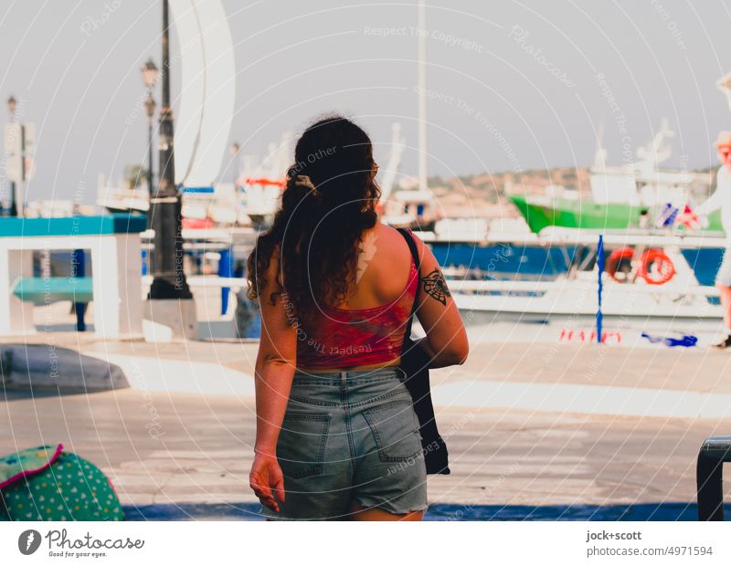 sommerlicher Spaziergang am Hafen Junge Frau feminin Rückansicht 18-30 Jahre langhaarig Agios Nikolaos Kreta Griechenland mediterran Wolkenloser Himmel