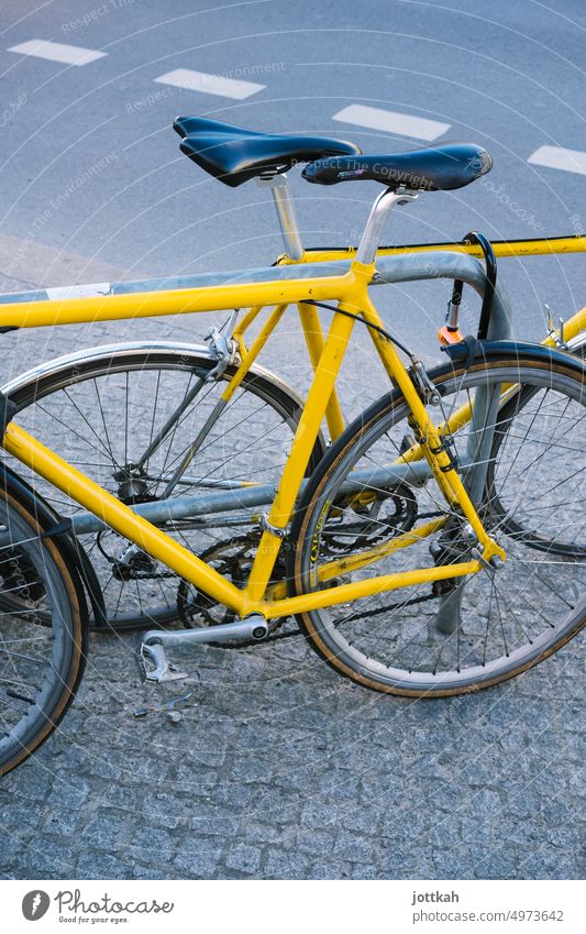 zwei gelbe Fahrräder lehnen an einem Fahrradständer Mobilität Verkehrswende Straße Farbe anschließen Sicherheit Fahrradfahren Verkehrsmittel Stadt