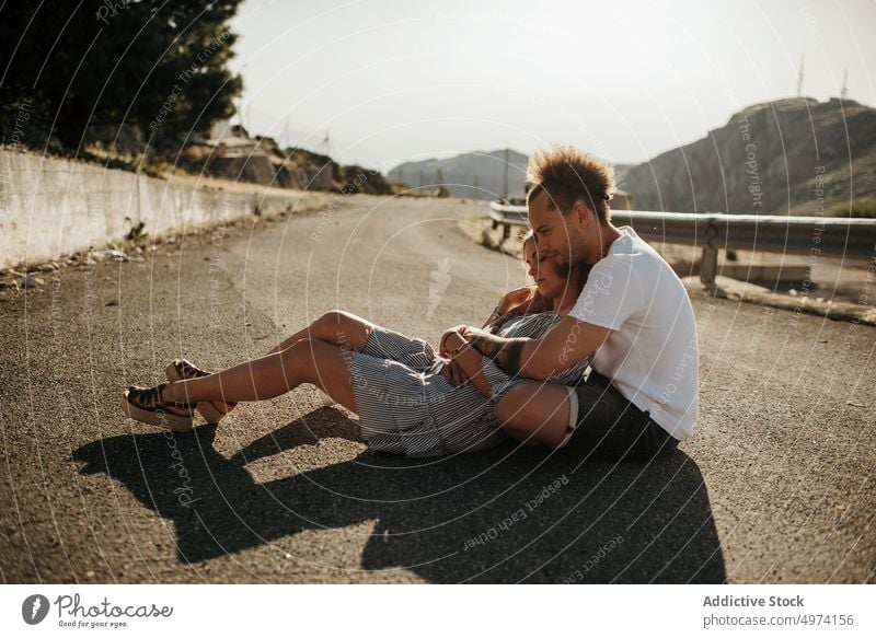 Junges Paar genießt einander, während es auf der Straße sitzt und sich umarmt Liebe Umarmung Hipster romantisch sinnlich Partnerschaft Glück bewundern Zuneigung