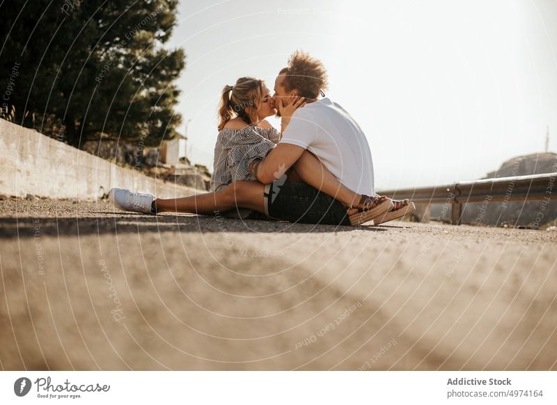 Glückliches junges Paar genießt einander, während es auf der Straße sitzt und sich umarmt Liebe Umarmung Hipster romantisch sinnlich Partnerschaft bewundern