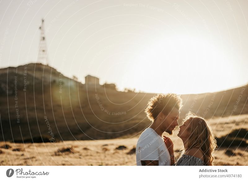 Trendiger Mann sieht seine Freundin an, während er in der Landschaft steht Paar Liebe romantisch Kuss Hand sanft Glück Termin & Datum Partnerschaft Balzen