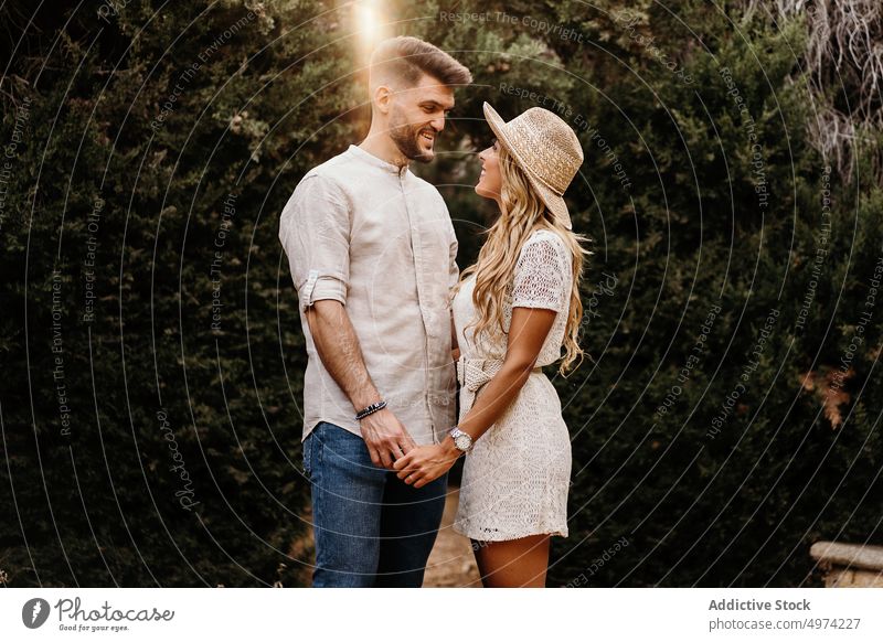 Paar hält sich an den Händen und genießt einander bei einem Date im Park Garten Liebe Freundin Termin & Datum Lächeln Anziehungskraft Glück Zusammensein