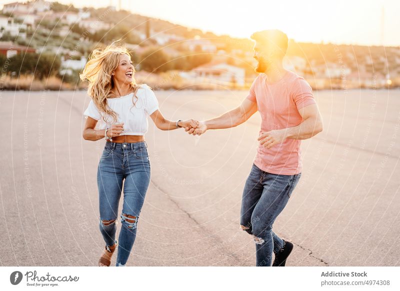 Erwachsenes Paar hat Spaß auf der Straße in einem Vorort bei Sonnenuntergang Vorstadt Lachen Glück Hügel Termin & Datum Spaziergang aufgeregt heiter reisen