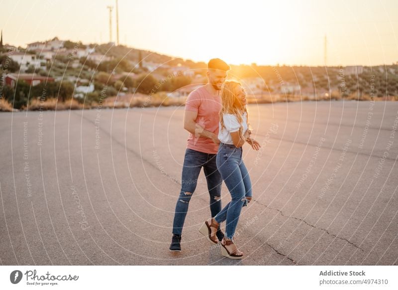 Erwachsenes Paar hat Spaß auf der Straße in einem Vorort bei Sonnenuntergang Vorstadt Lachen Glück Hügel Termin & Datum Spaziergang aufgeregt heiter reisen
