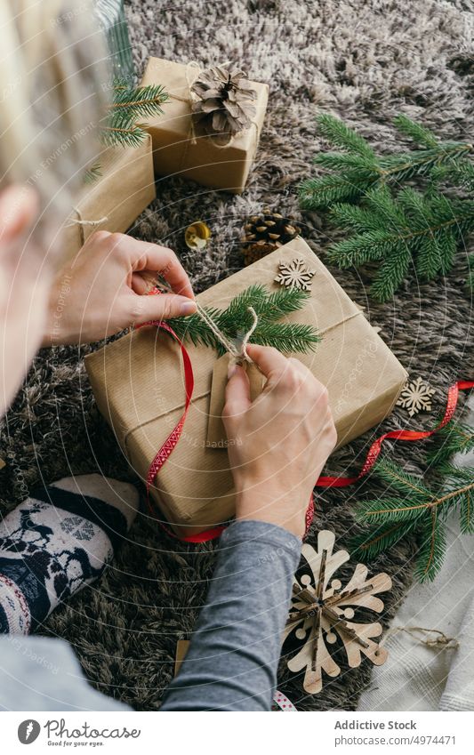 Frau packt ein Weihnachtsgeschenk ein im Innenbereich Weihnachten Überraschung Kasten Freizeit Verpackung Feier fröhlich Geschenk gold Hand handgefertigt