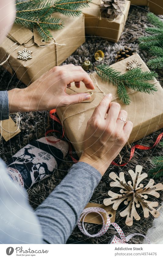 Frau packt ein Weihnachtsgeschenk ein im Innenbereich Weihnachten Überraschung Kasten Freizeit Verpackung Feier fröhlich Geschenk gold Klingel Hand