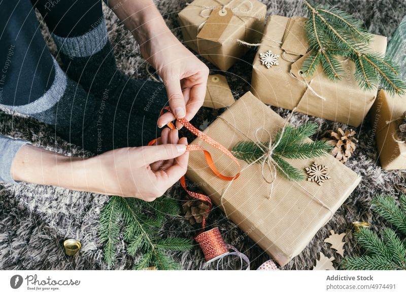 Nahaufnahme der Frau Hände Verpackung eines handgefertigten Weihnachtsgeschenk im Innenbereich Weihnachten Überraschung Kasten Freizeit Feier fröhlich Geschenk