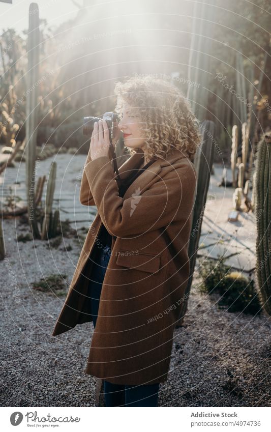 Porträt einer schönen, lockigen, blonden Frau mit einer Retro-Kamera Model im Freien Winter Gesicht Accessoire Bekleidung Fotokamera Mantel selbstbewusst