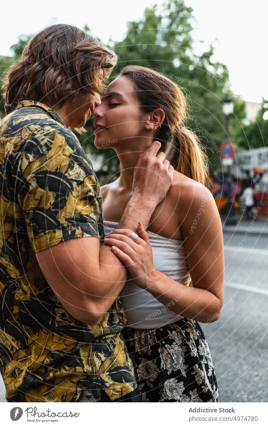 Küssendes Paar auf städtischem Hintergrund Kuss Zusammensein verliebt kuscheln Harmonie Sommer jung Teenager romantisch Glück Partnerschaft Lächeln Liebe sanft