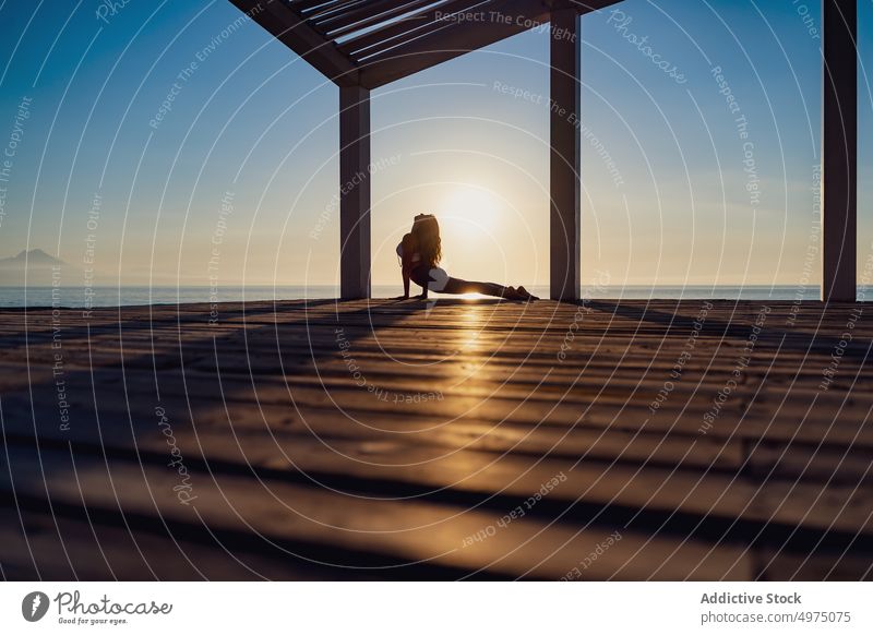 Flexible Frau macht Yoga am Strand Pose Asana Sonnenaufgang Seeküste Dehnung üben Konzentration Harmonie Gesundheit Gleichgewicht sich[Akk] entspannen