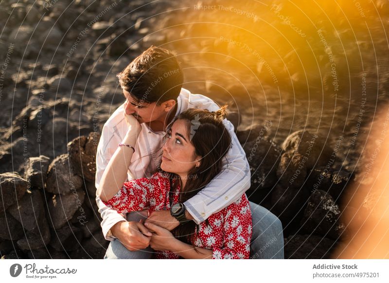 Entspanntes junges ethnisches Paar, das sich an der felsigen Küste umarmt kuscheln sich[Akk] entspannen Meeresufer romantisch Zusammensein Erholung Stil Natur