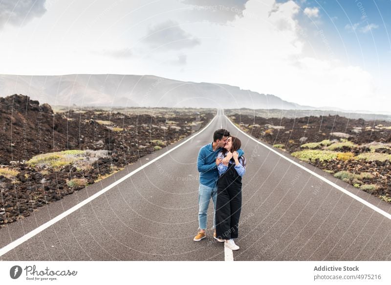 Junge stilvolle Paar umarmt und zu Fuß auf der Straße im Hochland Spaziergang Zusammensein Berge u. Gebirge Natur Partnerschaft Feiertag Reisender Abenteuer