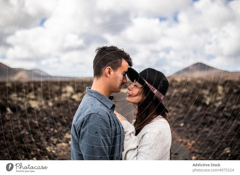 Fröhlicher junger Mann mit seiner Freundin in einem wilden Tal in der Nähe von Vulkanen auf den Kanarischen Inseln Paar Umarmung Liebe Berge u. Gebirge Urlaub