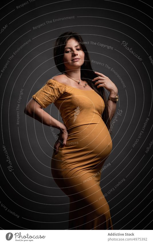 Elegante schwangere Frau im Maxikleid Bauch verträumt erwarten mütterlich Mutterschaft Schwangerschaft elegant Liebe gelb Baby Pflege Angebot brünett charmant