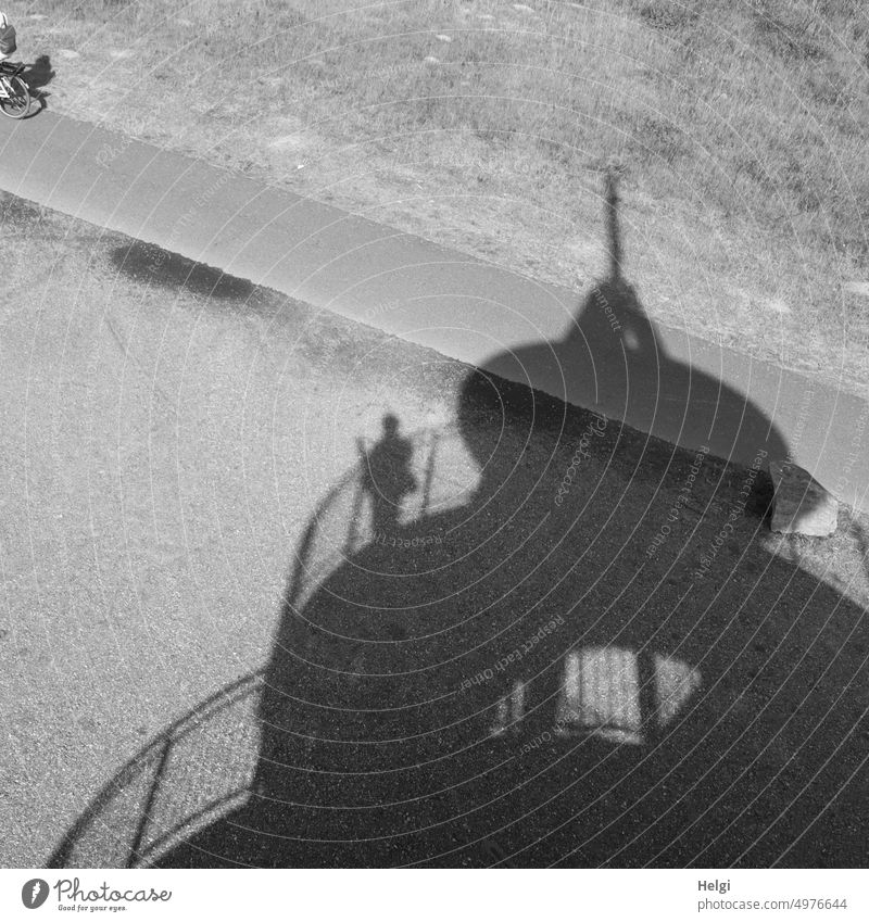 Schattendasein - Schatten eines Aussichtsturmes mit einer Person, die am Geländer steht Schattenwurf Turm Silhouette Licht Sonnenlicht Radweg Radfahrer