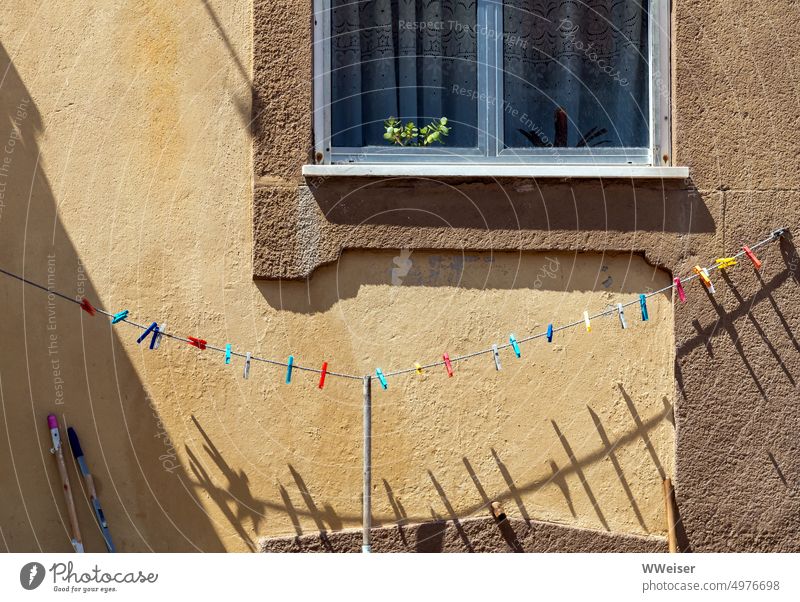 Alles nur Fassade: In einer kleinen südlichen Stadt warten die Wäscheklammern vor dem Haus auf den Waschtag Wohnhaus gelb sonnig warm bunt Wäscheleine Schatten