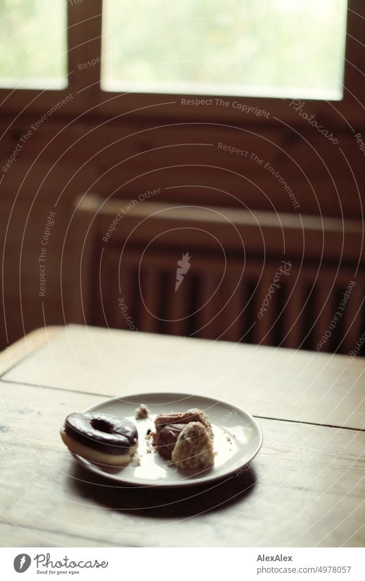 Teller mit Kuchen -  Muffin - Donut  - steht auf einem Holztisch in einem Gartenhäuschen vor dem Fenster Tisch süß Lebensmittel Teilchen Dessert Backwaren