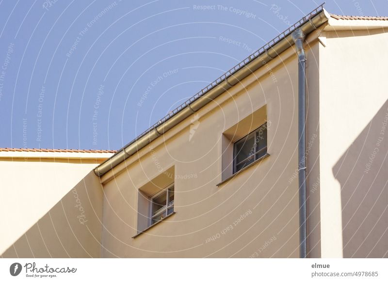 Blick auf zwei kleine Fenster auf der Schattenseite eines Wohnhauses / Mietpreise Mietshaus wohnen Mietpreisbremse Mietpreisbindung bezahlbarer Wohnraum