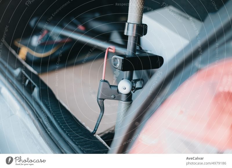 Close up von Elektro-Roller Lenker in einem Auto offen Kofferraum. Transport eines modernen und umweltfreundlichen Fahrzeugs vom Geschäft zur Straße. Nutzung neuer Transportmittel. Städtischer Lebensstil
