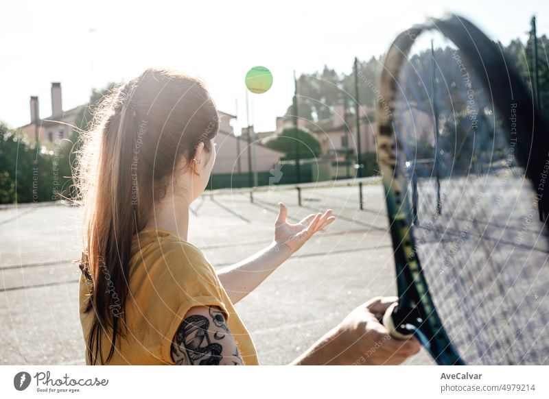 Junge Frau, die einen Tennisschläger hält und bereit ist, einen Tennisaufschlag zu machen, der Schülern gezeigt wird. Lehren neue Wege der Übung mit Spaß. Der Trainer motiviert und trainiert, um Ziele und Wünsche zu erreichen. Gesundes Leben und Stil