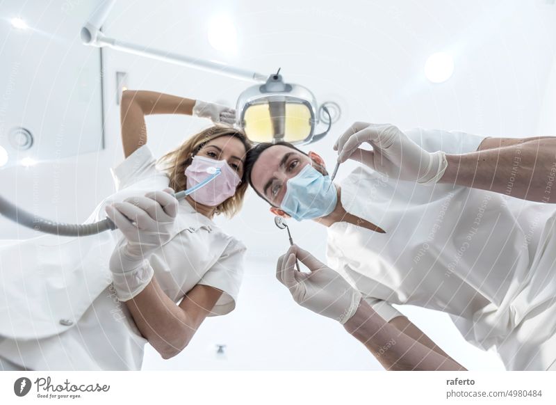 Porträt von männlichen und weiblichen Zahnärzten mit Masken in einer Zahnklinik aus niedrigem Winkel Zahnarzt Zahnmedizin Mann Klinik Mundschutz Frau