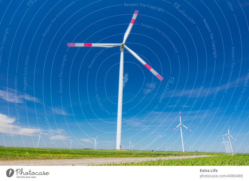 Blick auf mehrere Windmühlen, Windgeneratoren, Turbinen, die durch Umwandlung von Bewegungsenergie erneuerbare und saubere Energie erzeugen Antenne Ackerbau