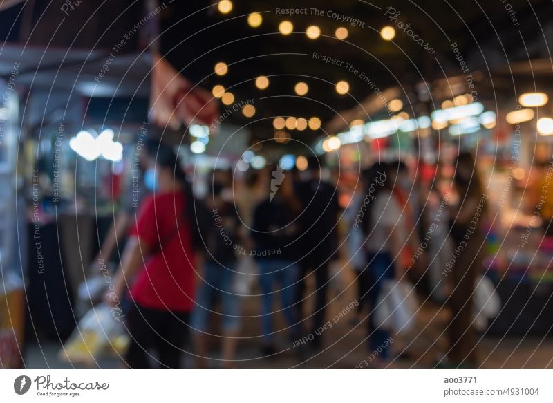 unscharfes Bild der Nacht Markt Festival Menschen zu Fuß auf der Straße mit Licht Bokeh für den Hintergrund. Unschärfe Stadtfest Person Party verschwommen Menge