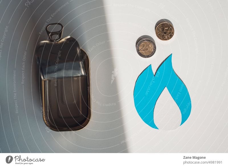 Erdgassymbol mit Münzen und einer leeren Blechdose, die zwischen Heizkosten und Lebensmitteln wählen Gas Gasverbrauch Benzingeld Einsparung