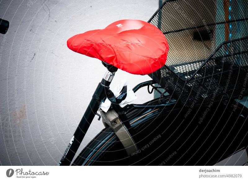 Mein Schwarzer Fahrrad Sattel hat einen roten Schutzüberzug. Kontrast Sommer Schutzplane steht Mauer & Wand Menschenleer Farbfoto Verkehrsmittel Außenaufnahme