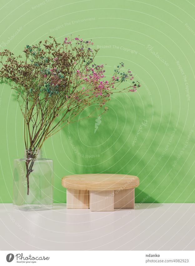Bühne für die Präsentation von Produkten, Kosmetika mit einem runden Holzpodest und einer Glasvase braun Sockel Pflanze Podest Kosmetologie Szene Schatten Form