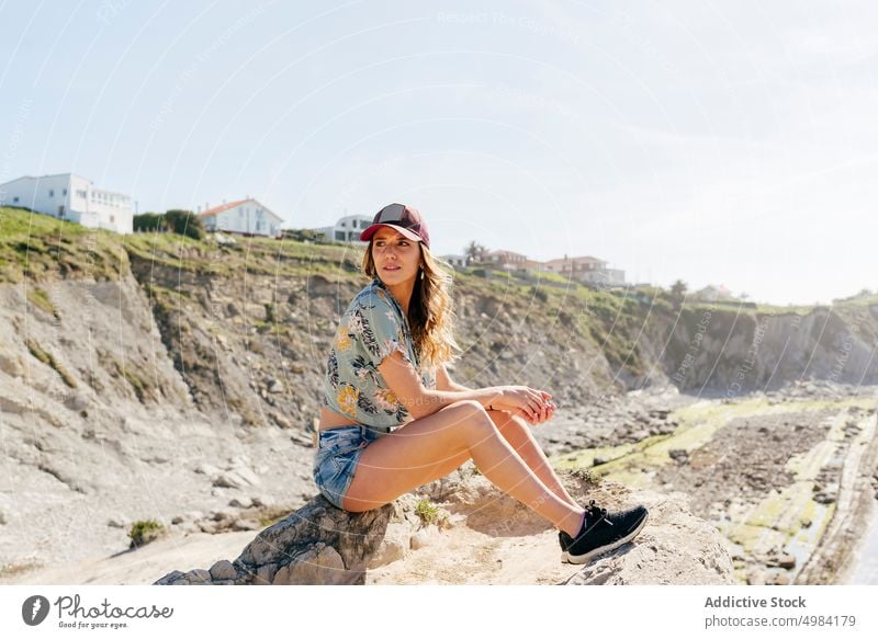 Frau ruht sich auf einem Felsen am Meer aus Sitzen sonnig Strand Reise Ausflug Transport Urlaub Abenteuer reisen Sommer Erholung Freizeit Feiertag authentisch