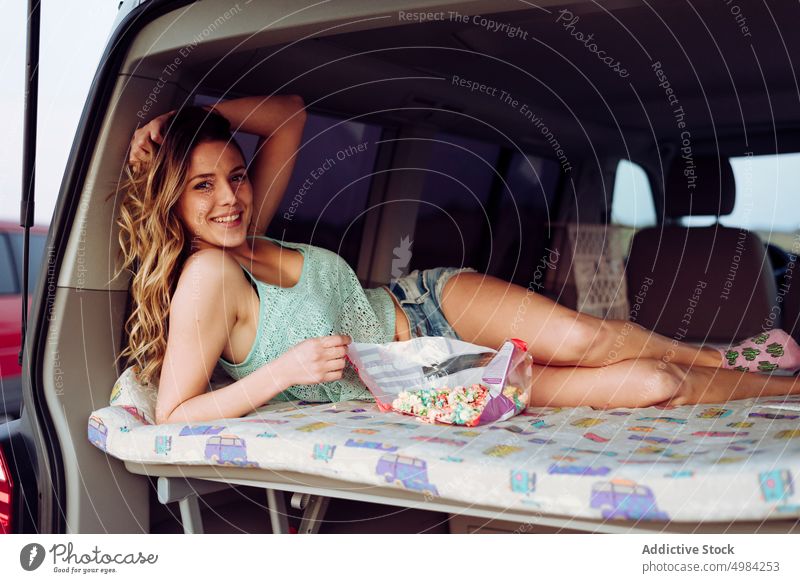 Blonde hübsche Frau ruht sich in einem Wohnwagen aus Popkorn Ausflug Menschen reisen Sommer Glück Lügen Straße Lächeln jung PKW Sonne Transport Teenager